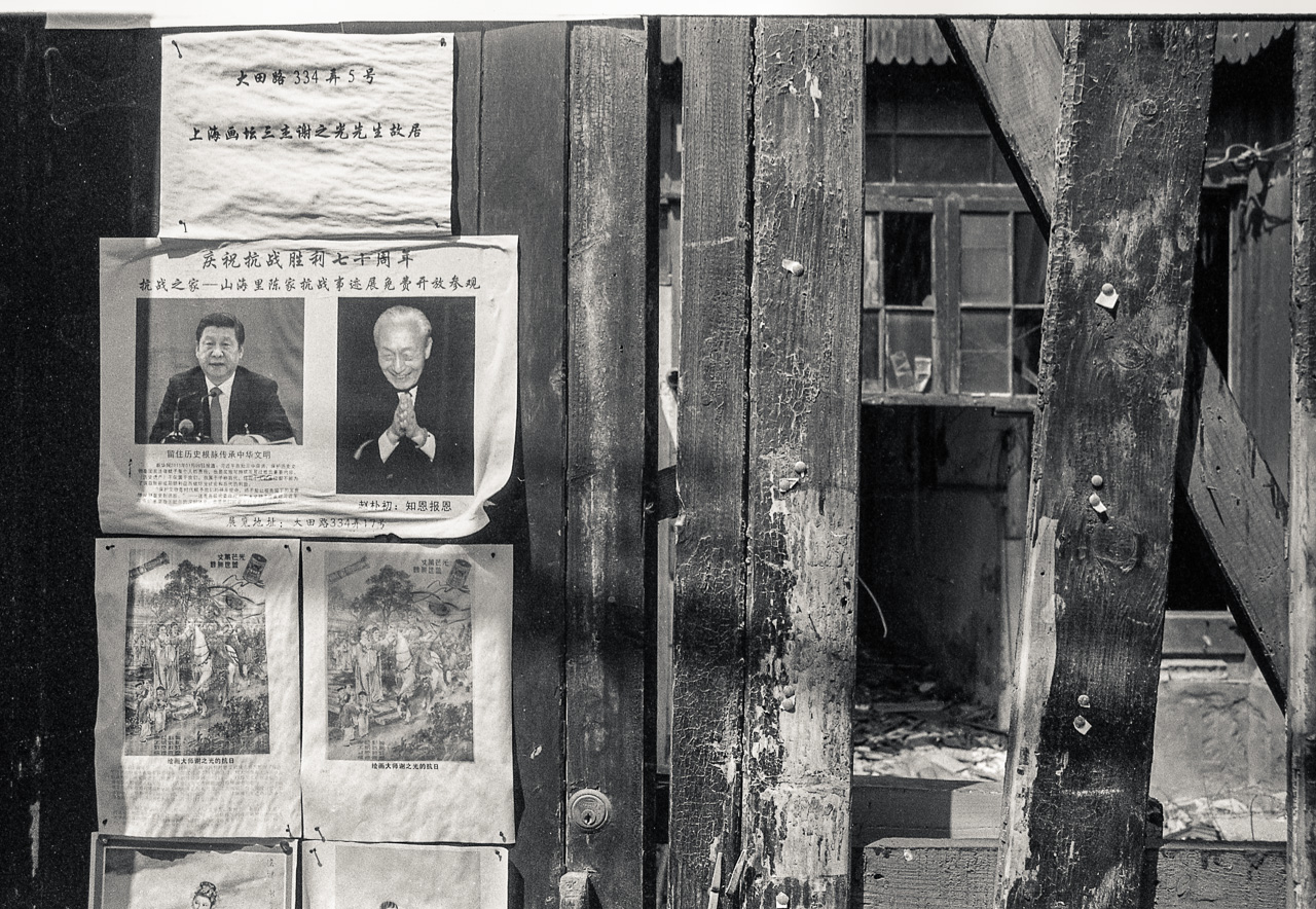#60 Cynical printouts all over a boarded up entranceway to a Shikumen house.
